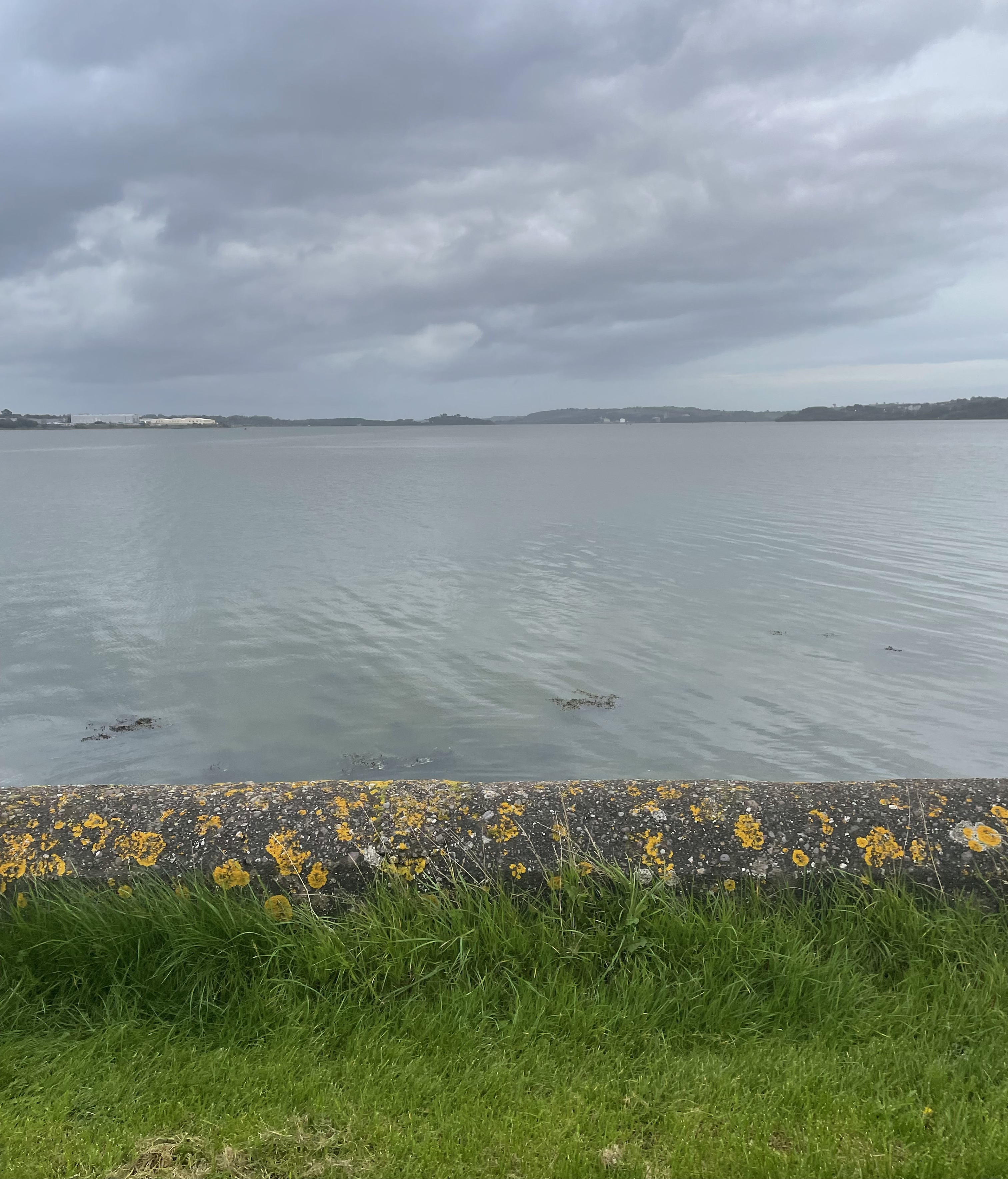 A river/ocean behind a small stone wall, I accidentally called this photo a sky lmao